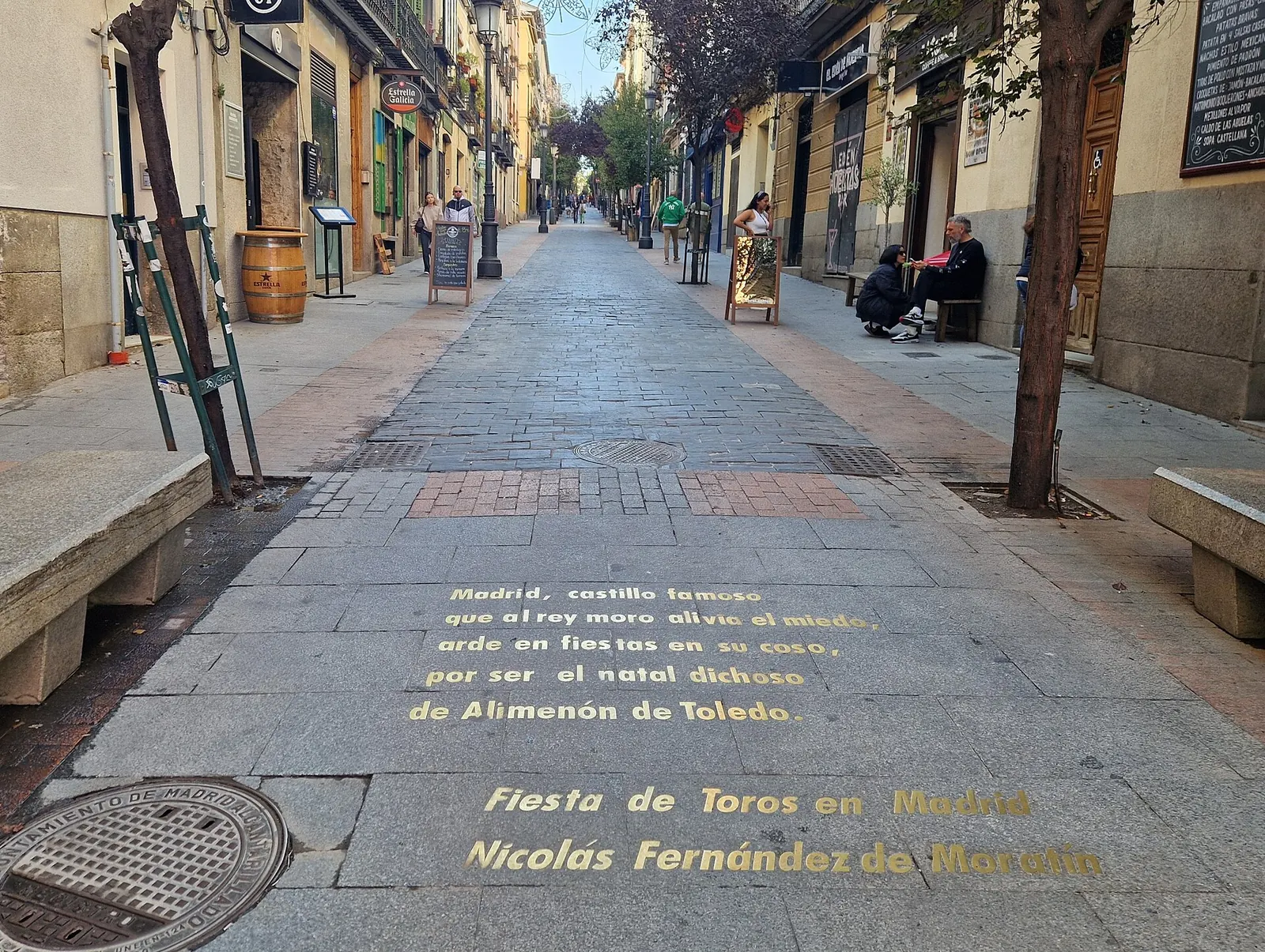 Calle de las Huertas in Madrid with gold lettering of a poem set into the paving stones